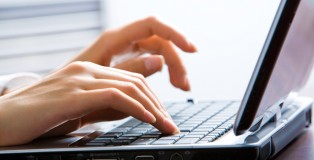 Image of female hands on the keys typing documents